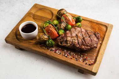 Izgara et ve sebze soslu restoran yemeği.