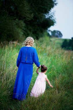 Anne ve kızı arasında alanları, yol boyunca el ele yürümek