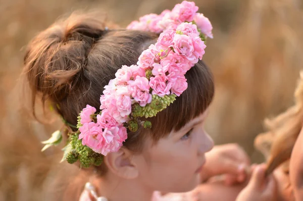 Wreath of roses on the head a little girl. Profile — Stock Photo, Image