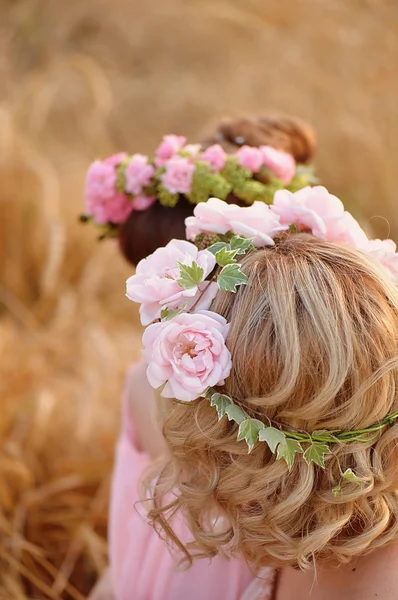 Kranzrosen auf dem Kopf des blonden, lockigen Haares. — Stockfoto