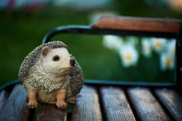 Statuette of a hedgehog standing on garden bench — Stock Photo, Image