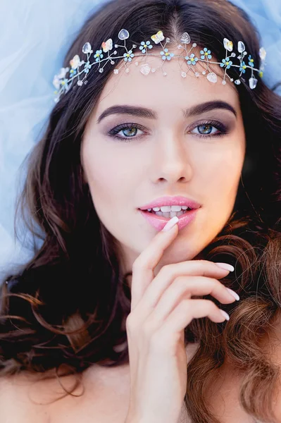 Close-up portrait of young brunette European type, with long curly hair and the decoration on the