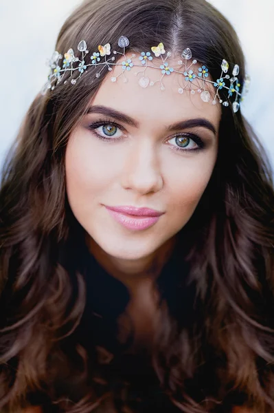 Close-up portrait of young brunette European type, with long curly hair and the decoration on the