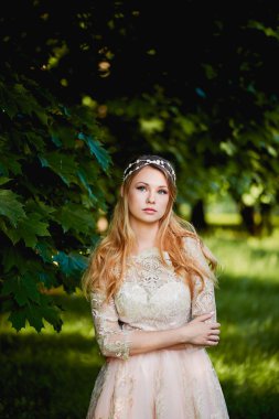 Güzel sarışın bir krem dantel elbise Bahçe arka planı