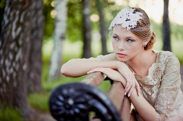 Belle blonde avec une coiffure et un voile assis sur un banc, look romantique — Photo