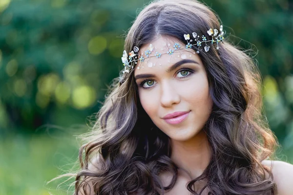 Close-up portrait of young brunette European type, with long curly hair and the decoration on the