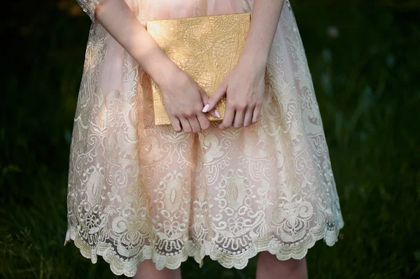 Handen met geschenkdoos. Op de achtergrond van de lace jurken — Stockfoto
