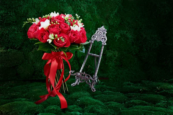 dense red bouquet of roses, tied with a  ribbon. Close