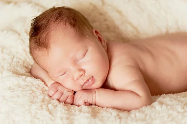 The baby, newly born, lies on the plaid and sleeping, handle the person — Stock Photo, Image