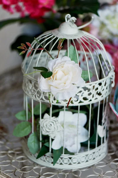 Gaiola de pássaro vintage decorada com flores feitas grinalda, rosas minúsculas, crisântemos e gypsophila paniculata galhos . — Fotografia de Stock