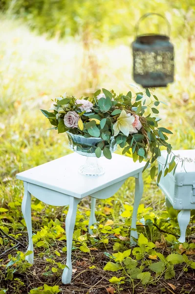 The decor for the wedding photo shoot. table, bent legs. Floral arrangement in a clear vase.