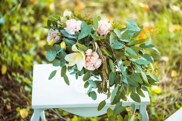 The decor for the wedding photo shoot. table, bent legs. Floral arrangement in a vase. — Stock Photo, Image