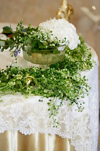 Dekorace svatební tabule s bílou hortenzií, krajkový ubrus a zelení — Stock fotografie