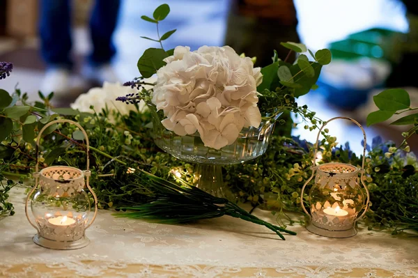 Décoration de table de mariage avec des hortensias blanches, une nappe en dentelle et des verts, des bougies — Photo