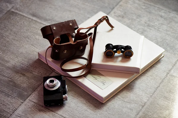 Fotolivro em couro brilhante, binóculos retro e câmera antiga. Criativa — Fotografia de Stock