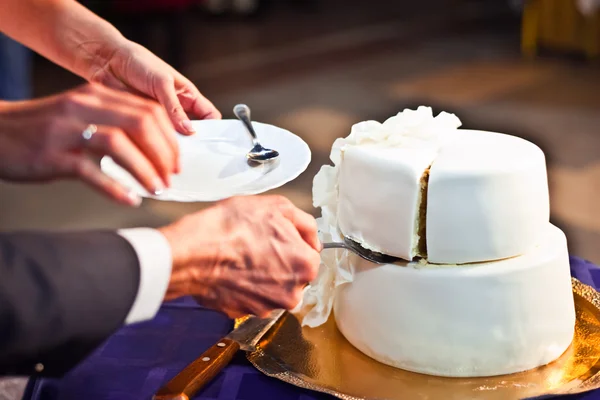 Руки жениха и невесты. Возьмите кусок свадебный белый торт лопатки — стоковое фото