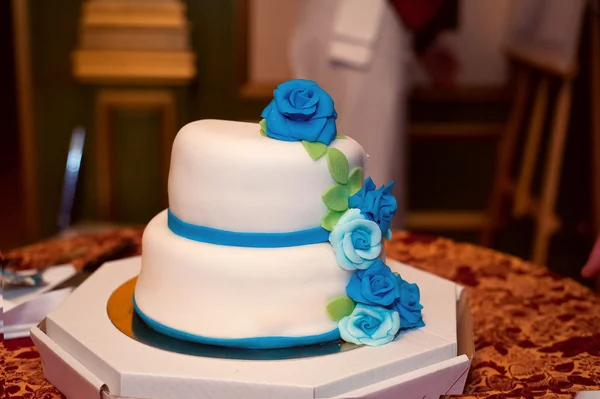 Свадебный торт в белой глазури с голубыми и бирюзовыми розами . — стоковое фото