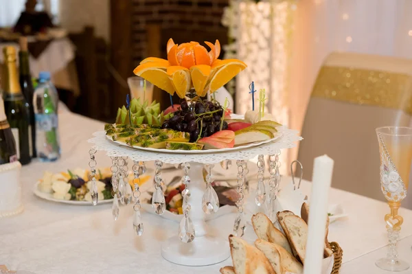 Fruitschaal op de tafel van de bruiloft. Peren, appels, druiven, kiwi, — Stockfoto