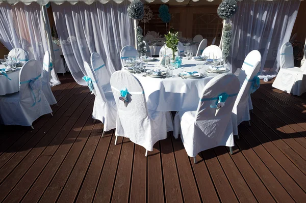 Sillas con cintas azules en la celebración de la boda la cubierta al aire libre — Foto de Stock