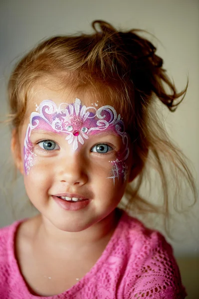 Bastante emocionante chica de ojos azules de 2 años con una pintura de la cara —  Fotos de Stock