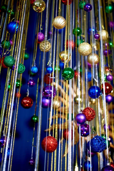 Новогодняя гирлянда мячей и дождь на голубую стену. Яркие праздничные краски. Празднование нового года. — стоковое фото