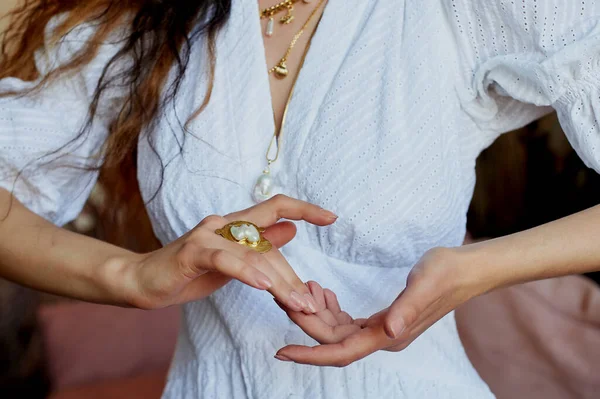 Prachtige vrouwenhanden in een gouden ring met een witte steen. Kunst en stijl — Stockfoto