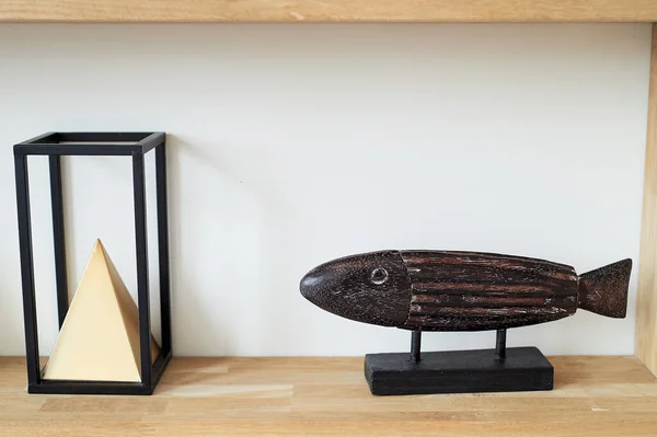 집에는 미니멀리즘적 인 스카 쉬 가 있다. 나무 물고기와 피라미드. 설계 — 스톡 사진