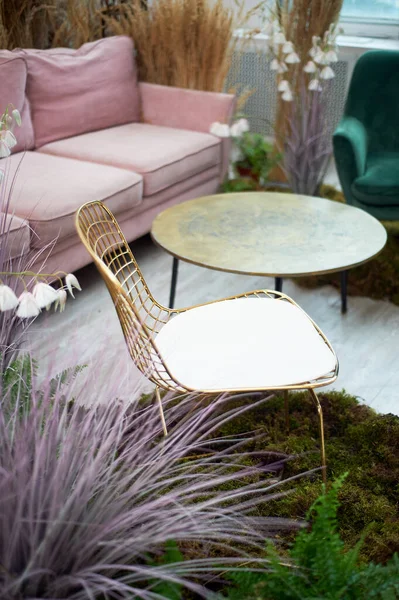 Una silla dorada con un respaldo de malla se encuentra en el musgo. Diseño ecológico.Interior elegante con cereales y flores secas. — Foto de Stock