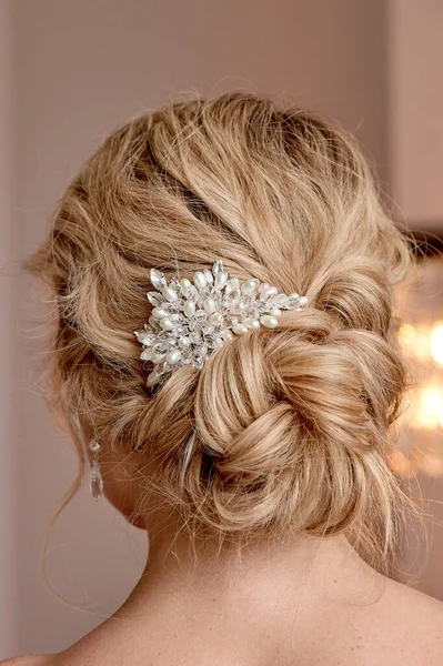 A classic wedding bun. The brides hair, hairdressing. Blonde with curly hair.