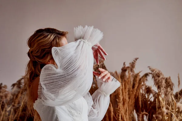 金髪の女の子が踊っている。豪華な白いウェディングドレスの袖。花嫁の朝. — ストック写真