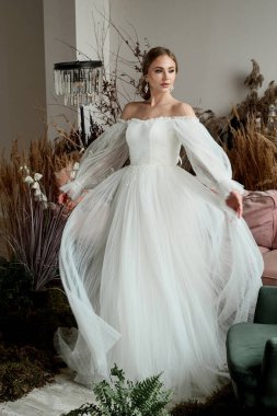 Evdeki kızın sabahki romantik atmosferi. Gelin, evde güzel bir elbise içinde kıvrılır. Her anın tadını çıkar.