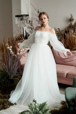 Evdeki kızın sabahki romantik atmosferi. Gelin, evde güzel bir elbise içinde kıvrılır. Her anın tadını çıkar.