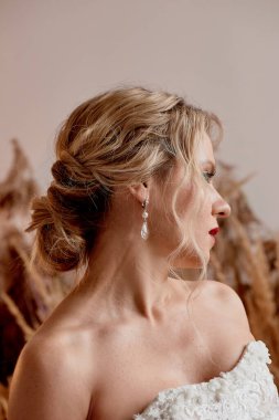 Gelinlik giymiş, dantel yakalı bir gelin. Profil, kırmızı ruj.