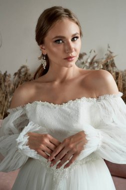 Beyaz elbiseli, güzel, klasik saç stili ve mükemmel koyu tenli bir gelin. Düğün sabahı..