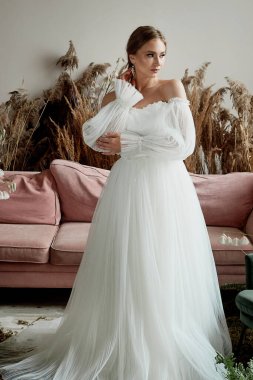 Açık omuzlu, beyaz, gür bir elbise içinde mükemmel koyu tenli gelin. Gelinin düğünden önceki sabahı..