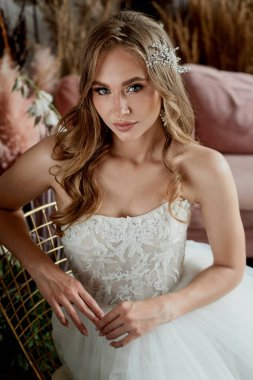 Gelinlik giymiş gelin. Mükemmel ciltli, makyajlı ve güzel saçlı genç bir manken. Mutlu bir gün. Evlilik..