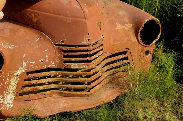 Zrezivělé staré auto zarostlé zelení. Opuštěné město, flotila. Makro — Stock fotografie