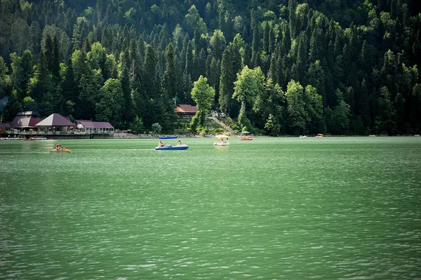 Catamarans on Lake Ritsa in Abkhazia. Walks on the water. Ecologically clean place in the mountains. — Stock Photo, Image