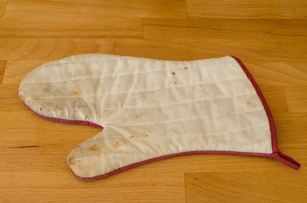 Old kitchen glove isolated on a wood table — Stock Photo, Image