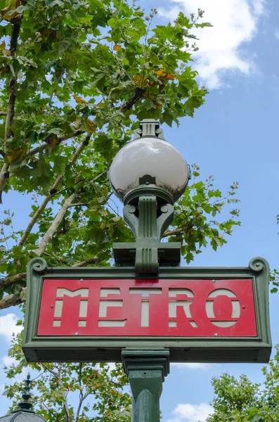 Geleneksel Paris metro işareti mavi bulutlu gökyüzü ile ağaçların çevresinde — Stok fotoğraf