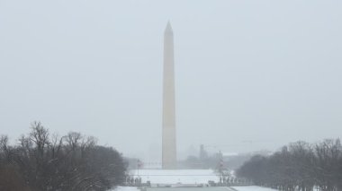 Washington D.C. 'deki Washington Anıtı' nın, Ulusal AVM 'den net ve soğuk bir manzarası var. İkonik dikilitaş sis ve tamamen karla kaplı bir manzarayla çevrilidir..