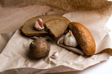 sarımsak, patates, ekmek ve tereyağı Kraft kağıt üzerinde
