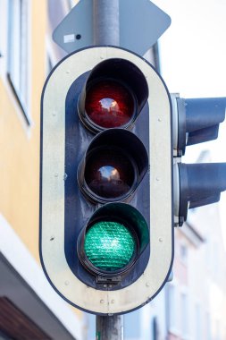 Yeşil ışığı olan trafik ışıkları şehir yolundaki araçlara yönelin diyor.