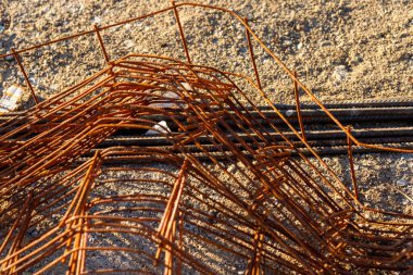 Paslı inşaat demiri bir inşaat alanında yerde soyut desenler oluşturuyor.