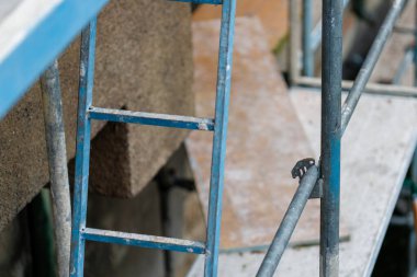 İnşaat iskelesinde mavi boyanmış metal merdiven.