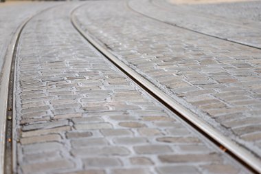 Parke taşı caddesinde tramvay rayları mesafeye doğru kıvrılıyor.