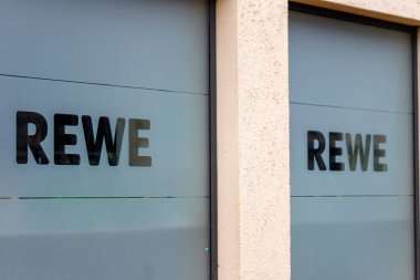 Bir perakende mağazasının buzlu camlarında görüntülenen Rewe marka ismi