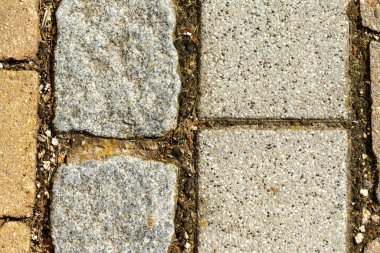 Olaysız taş ve beton kaldırımlar desenli bir arka plan oluşturuyor