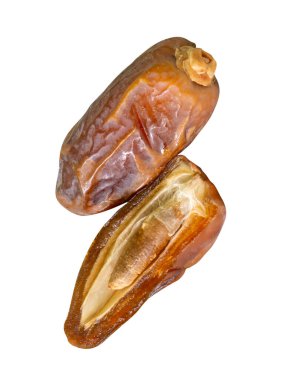 Olgun kurumuş palmiye meyvelerinin yarısı yığın halinde beyaz arka planda kırpma yolu ile izole edilir. Müslümanlar için Ramazan ayında iftar yemeği kavramı