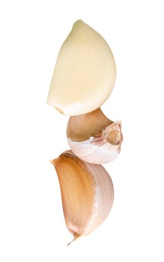 Kümelenmiş üç sarımsak karanfilinin yan görünümü kırpma yolu ile beyaz arkaplanda izole edilmiştir..